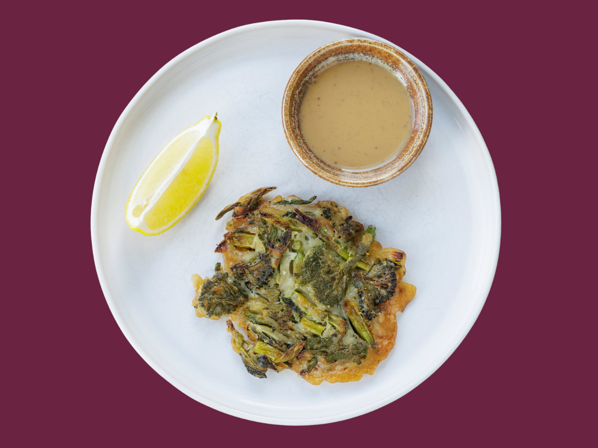 Tallerken med pandekager lavet af broccoli. Citron og gomadressing ved sidne af